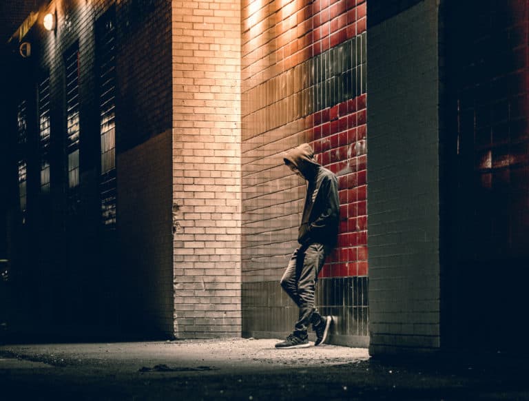 Man looking delected in city at night
